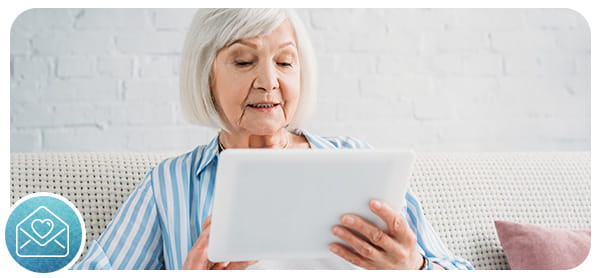 Woman with white hair using a tablet computer