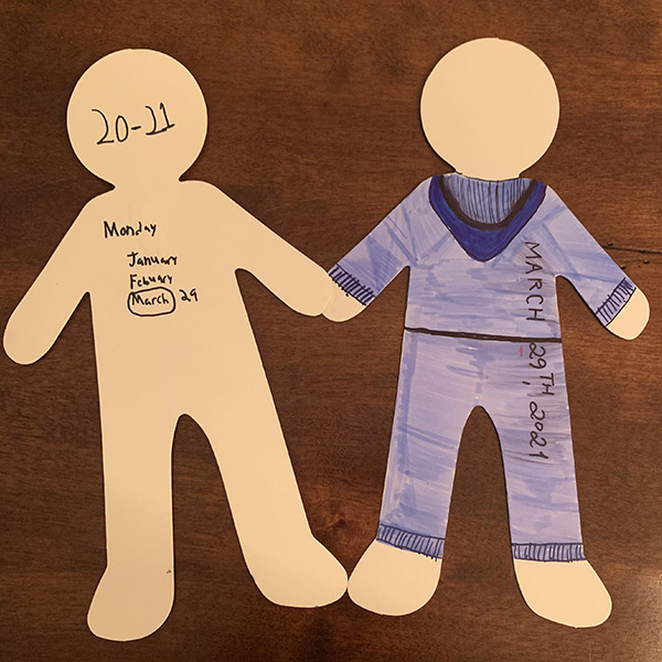 A chain of paper dolls, colored with crayons, represents the patient as he sees himself versus how the art therapist sees him.