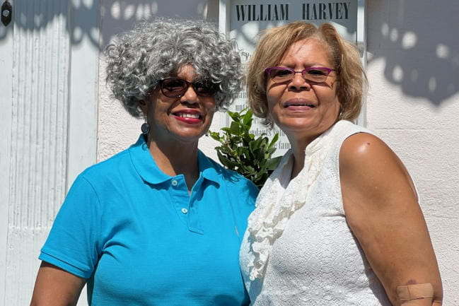 Carol Richburg with her sister Cathy Crump. Richburg wears the wig given to her by Racquets for Recovery.