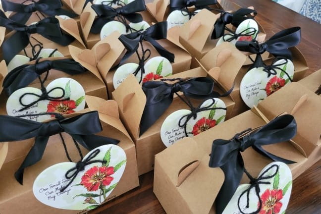 Group of gift boxes on a table, each with a marigold printed on the gift tag